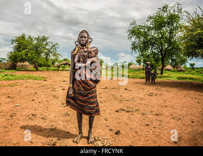 Frau aus dem afrikanischen Stamm Mursi mit ihrem baby Stockfoto