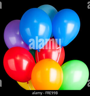 Gruppe von bunten Luftballons auf Bändern auf schwarzem Hintergrund isoliert Stockfoto