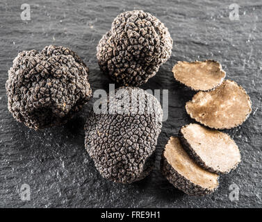 Schwarze Trüffel und Trüffel-Scheiben auf dem Brett Graphit. Stockfoto