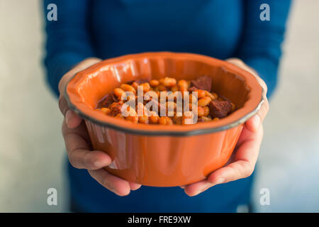 Weibliche Hände mit Bohnen Suppe in Schüssel, Nahaufnahme Stockfoto