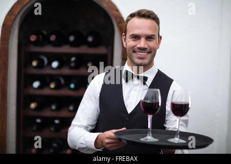 Kellner mit Tablett mit Rotwein Stockfoto