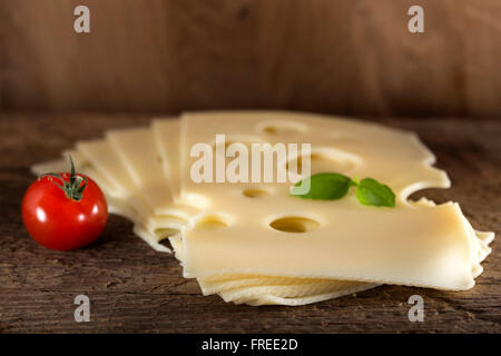 Scheiben Emmentaler Käse auf einem hölzernen Hintergrund Stockfoto