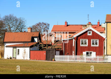 Kalmar, Schweden - 17. März 2016: Eine alte rote Holzhaus mitten in der Stadt mit modernen Gebäuden im Hintergrund. WHI Stockfoto