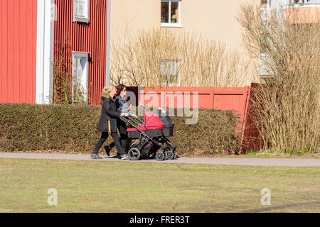 Kalmar, Schweden - 17. März 2016: Zwei Frauen gehen und Geste und schieben ihre Brio Kinderwagen vor ihnen. Wirkliche Leute je Stockfoto