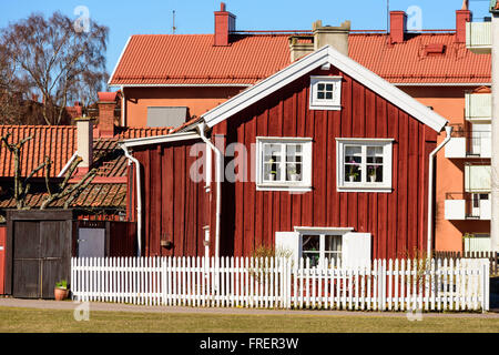 Kalmar, Schweden - 17. März 2016: Eine alte rote Holzhaus mitten in der Stadt mit modernen Gebäuden im Hintergrund. WHI Stockfoto