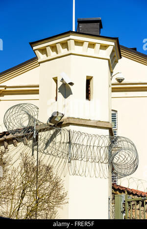 Ein kleines Gefängnis Wachturm mit Stacheldraht rundherum. Ferngesteuerte Kameras und Scheinwerfer an der Turmwand befestigt sind. Stockfoto