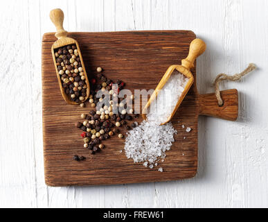 Salz und Pfeffer in hölzernen Schaufeln auf Holzbrett, Ansicht von oben Stockfoto