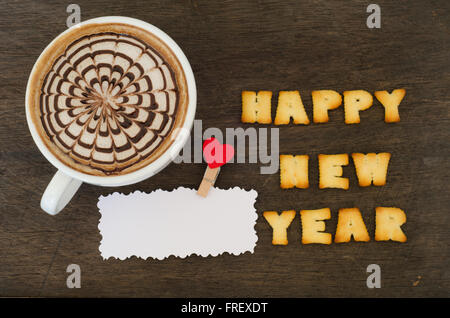Eine Tasse Latte Kunst und Alphabet "Frohes neues Jahr", hergestellt aus Brot cookies Stockfoto