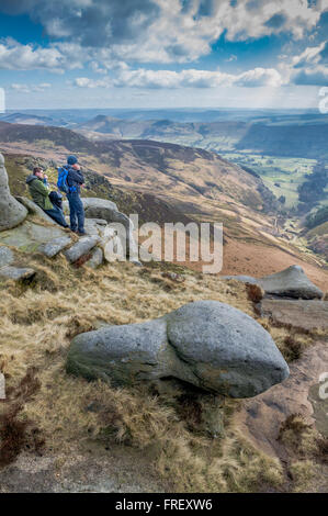 Wanderer auf ausgesetzt Gritstone Felsen am Kinder Scout mit Blick auf Edale im Peak District in Derbyshire, England, Großbritannien Stockfoto