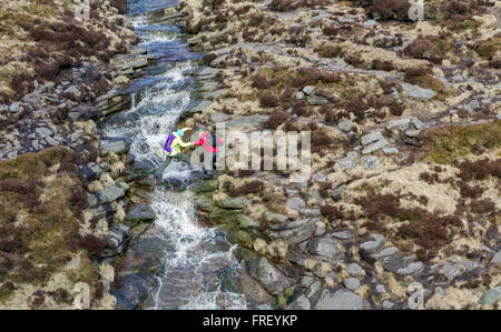 Wanderer durchqueren schleift Bach an Kinder Scout im Peak District in Derbyshire, England, Großbritannien Stockfoto