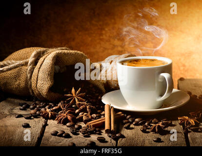 Tasse Kaffee und Gewürze auf Holztisch Stockfoto