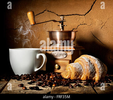 Frische Croissant und Kaffee Körner auf Holztisch Stockfoto