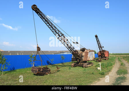 Alte Abseilfaden in der Nähe von dem blauen Zaun. Alte Geräte für das Graben der Erde in Kanälen und Steinbrüchen. Stockfoto