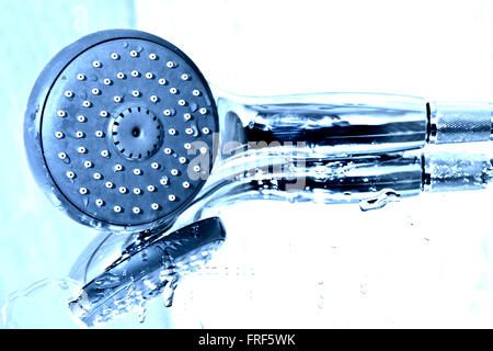 Handbrause und Wasser in der Badewanne. Stockfoto