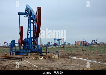 Nickend Esel in Onshore-Ölfeld in der Umgebung von Baku, der Hauptstadt Aserbaidschans. Eine Szene zeigt Öl Produktionsanlagen Stockfoto
