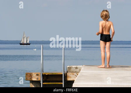 GOTLAND, Insel der Wikinger. -05/08/2007 - Europa - von einem Ponton, ein kleiner Junge ist ein schönes Segelboot bewundern.   -Laurent Stockfoto