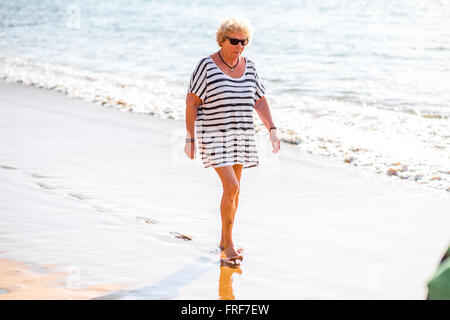 SANTA CRUZ, Teneriffa Insel, Spanien - 23. Dezember 2015: ältere Spanierin walking am Teresitas Strand am Morgen in San Stockfoto