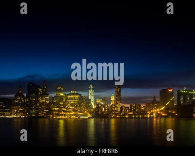 Skyline von Manhattan in der Nacht mit Brooklyn Bridge, New York, USA. Stockfoto