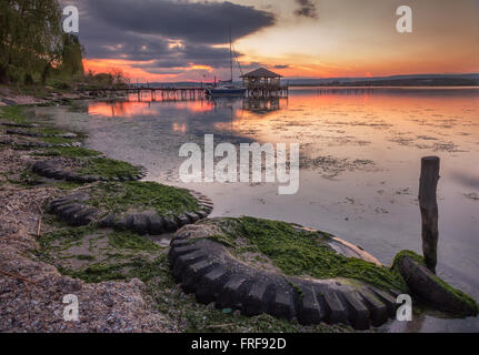 Schöner Sonnenuntergang mit Reifen und alten Fischer-Hütte an der Küste von See Stockfoto