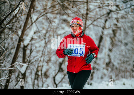 Frau mittleren Alters Athlet auf Winter schneebedeckte Allee im Park in Chelyabinsk Winter Marathon laufen Stockfoto