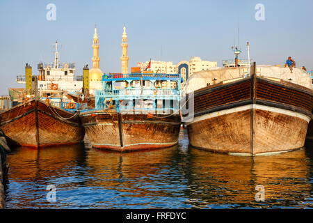 Dubai - Sharjah. Dhow-Boote in den Hafen von Sharjah und Moschee auf der Rückseite, Vereinigte Arabische Emirate Stockfoto