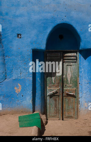 Lokale Architektur eines grünen Tür und blau bemalte Haus in einem Dorf in der Nähe von Medinet Habu auf der Westbank von Luxor, Nil Senke, Ägypten. Stockfoto