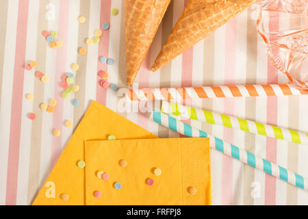 Bunte Zucker Streusel, Strohhalme und Eistüten. Vorbereitung für Party oder Feier. Konzept der Food-Styling. Stockfoto