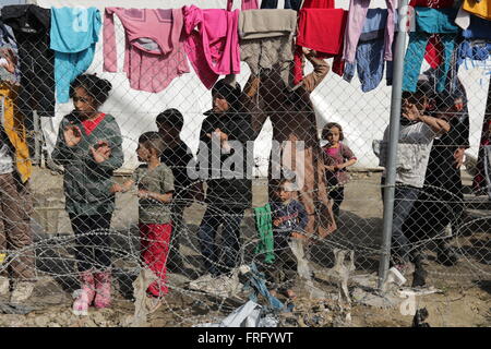 Idomeni, Griechenland, 22. März 2016. Frauen und Kinder halten Sie einen Zaun in einem provisorischen Lager für Flüchtlinge und Migranten an der griechischen mazedonischen Grenze, in der Nähe des Dorfes Idomeni. Bildnachweis: Orhan Zolak / Alamy Live News Stockfoto