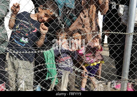 Idomeni, Griechenland, 22. März 2016. Frauen und Kinder halten Sie einen Zaun in einem provisorischen Lager für Flüchtlinge und Migranten an der griechischen mazedonischen Grenze, in der Nähe des Dorfes Idomeni. Bildnachweis: Orhan Zolak / Alamy Live News Stockfoto