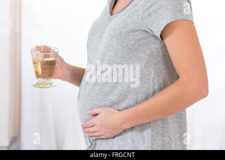 Schöne glückliche schwangere Frau mit einer Tasse Tee Stockfoto
