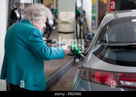 Eine ältere Dame füllt ihr Tank mit Benzin an der BP-Tankstelle am Wellington Road, London Stockfoto