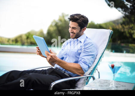 Kluger Mann mit digital-Tablette in der Nähe von Schwimmbad Stockfoto