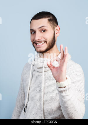 Schöner junger Mann zeigt OK Sign. Stockfoto