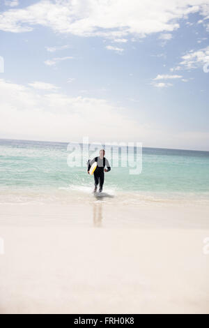 Surfer am Strand mit einem Surfbrett Stockfoto