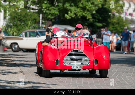 Meran, Italien - 9. Juli 2015: Ausfahrt nach der Zeitkontrolle der roten Fiat Simca 508 C mit der Nummer 21 auf der Passerpromenade Stockfoto