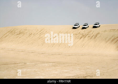 drei 4 x 4 Autos Alligned und bereit, von einer großen Sanddüne in der Wüste Sahara Tunesien herabzusteigen, Stockfoto