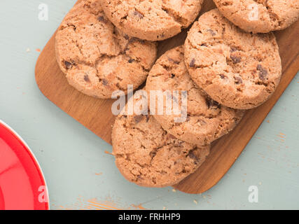 Schokoladenkekse auf hölzernen Schneiden an Bord von oben in der Nähe auf. Süße Speisen, Nachtisch oder Snack. Stockfoto
