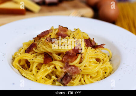 Traditionelle italienische Pasta Spaghetti Alla Carbonara mit Becon, Käse und Agg Eigelb auf weißen Teller Stockfoto