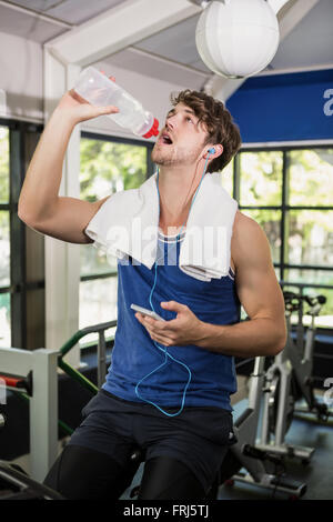 Man Trinkwasser und Musik hören bei spinning Klasse Stockfoto