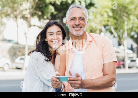 Fröhliches paar mit Telefon Stockfoto