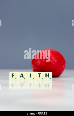 Rote Gehirn mit Glauben Zeichen auf dunklem Hintergrund Stockfoto