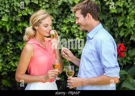 Junger Mann mit Blume Frau Weingläser mit gedrückter Stockfoto