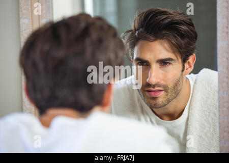 Der Mensch sich im Spiegel zu betrachten Stockfoto