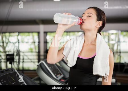 Frau am Laufband Trinkwasser in Turnhalle Stockfoto