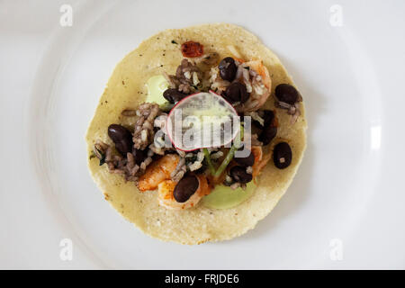 Garnelen Sie Taco Tacos mit Reis, schwarze Bohnen grüne Zwiebel sorgfältig auf kleine Tortilla-Schale arrangiert mit transluzenten Radieschen garniert Stockfoto