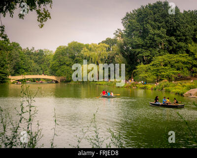 Ruderboote auf dem See, Central Park, New York City, USA. Bow Bridge im Hintergrund Stockfoto