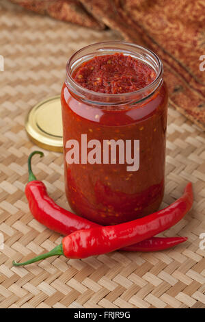 Glas mit traditionellen indonesischen Sambal und frische rote Chilischoten Stockfoto