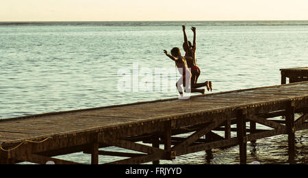 Kinder springen von pier Stockfoto