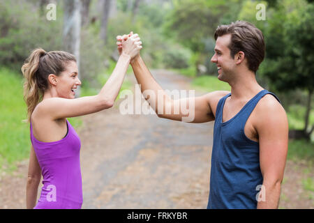 Fröhliche Freunde Hand in Hand im Wald Stockfoto