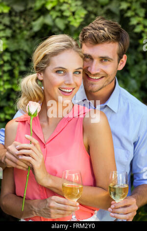 Porträt von glücklicher Mann Frau Blume einzuräumen, Weingläser mit gedrückter Stockfoto